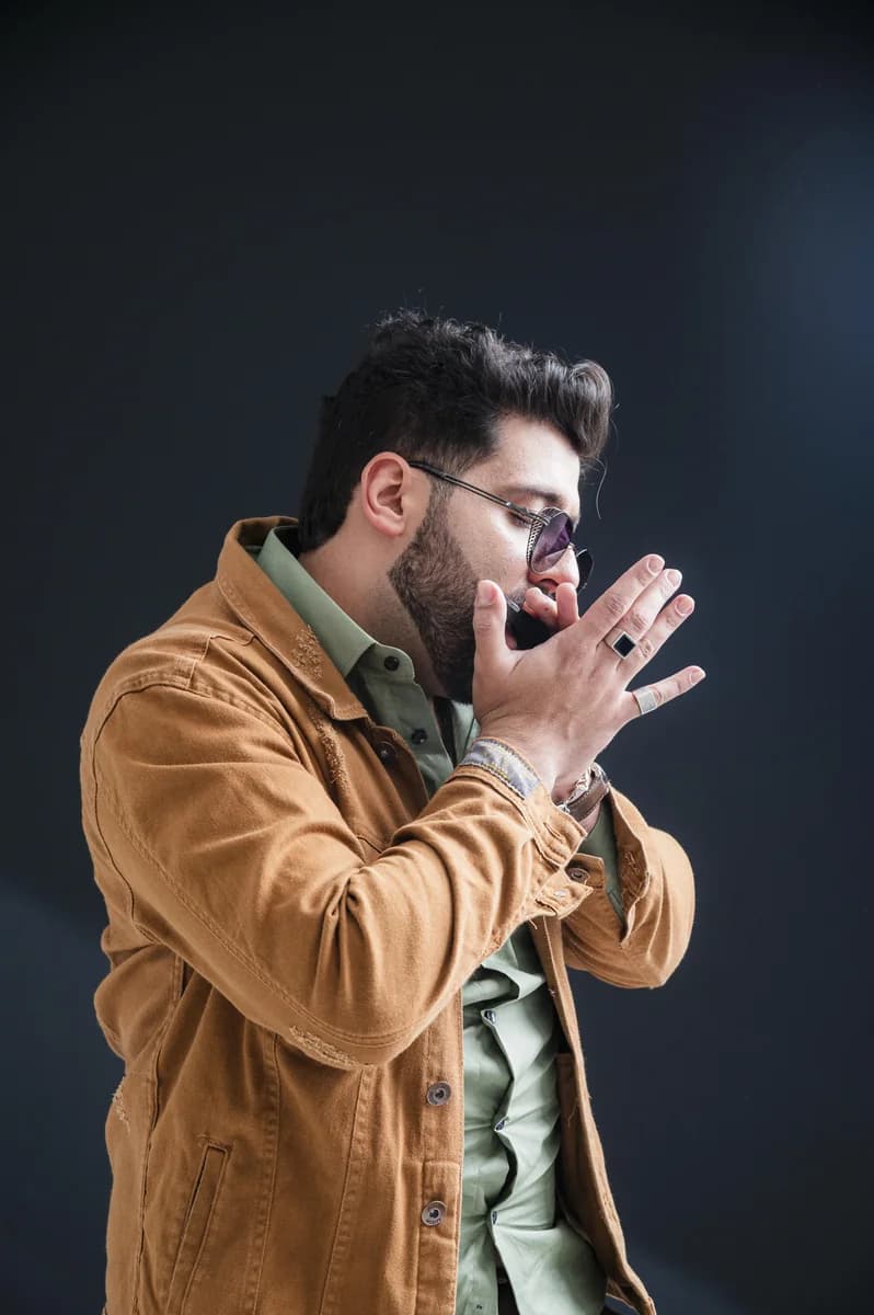 Geovani Medeiros tocando gaita em retrato de estúdio sobre fundo escuro